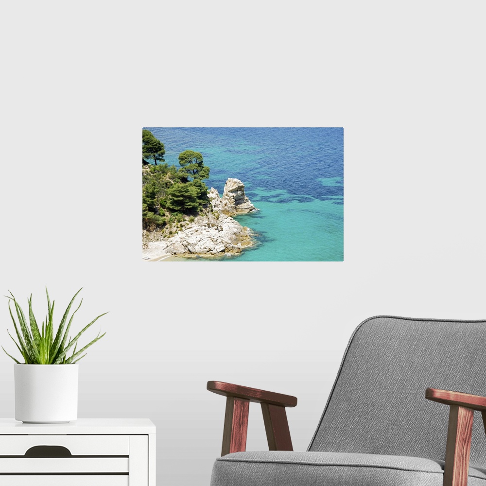 A modern room featuring Clear blue water, rock cliffs and Mediterranean pine trees on coast of Chalkidiki peninsula , Gre...