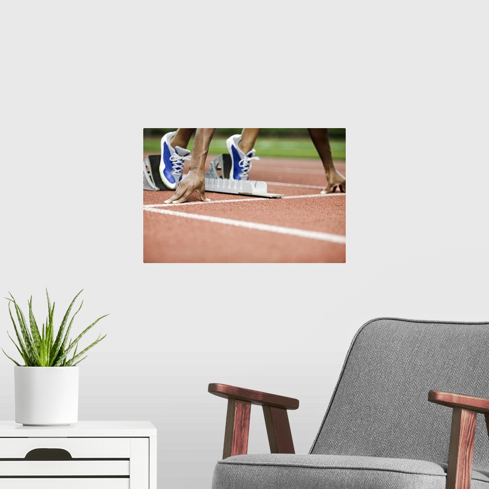 A modern room featuring Large photo on canvas of a track athlete at the starting line about to take off sprinting.