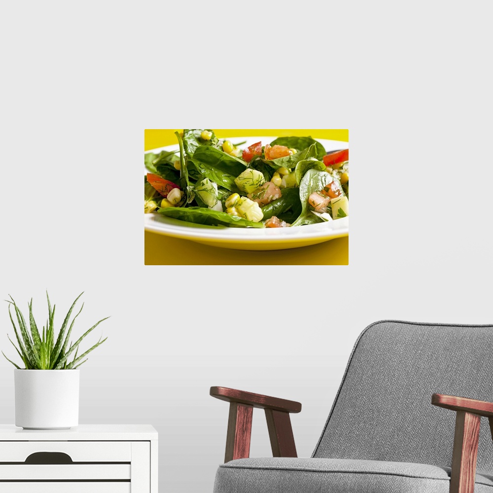 A modern room featuring Spinach and sweet corn salad with tomatoes, cucumber and dill, close-up