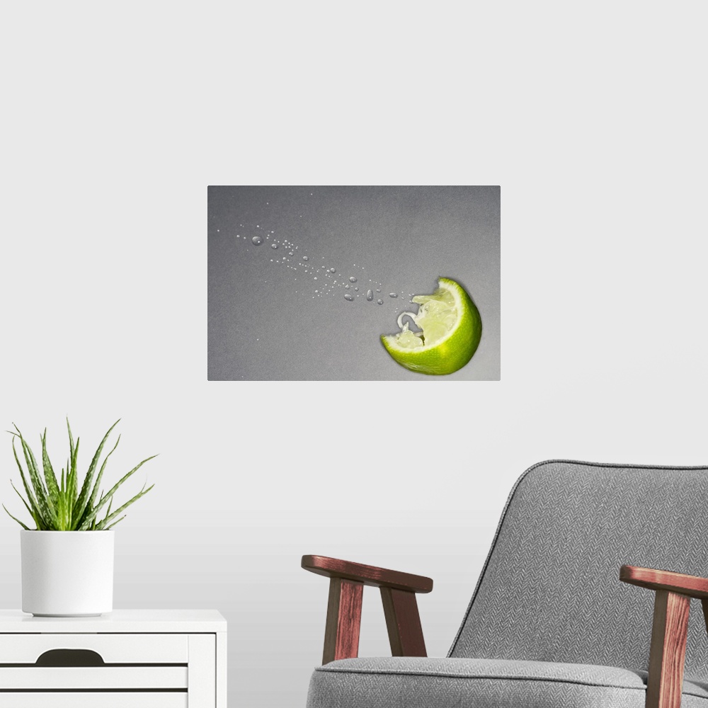 A modern room featuring Large canvas photo art of a lime slice with juice coming out on a neutral background.
