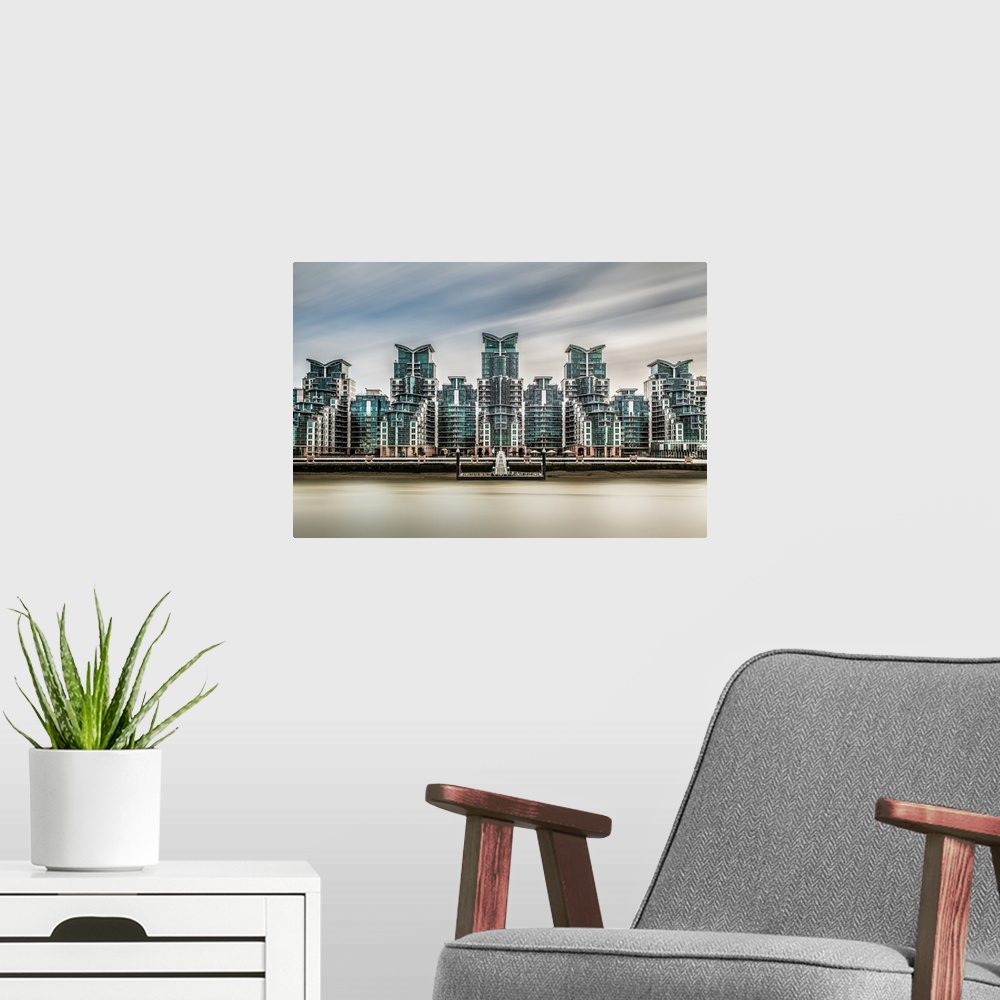 A modern room featuring Long exposure of the five ultra modern towers of Saint Georges Wharf, with the rives Thames in th...