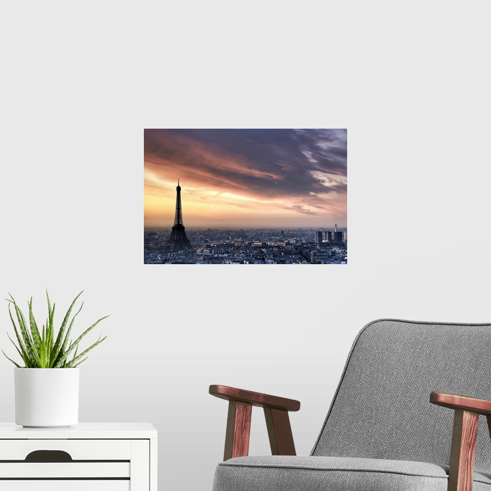 A modern room featuring Big, horizontal photograph of the sun rising through wispy clouds as the Eiffel Tower looms over ...