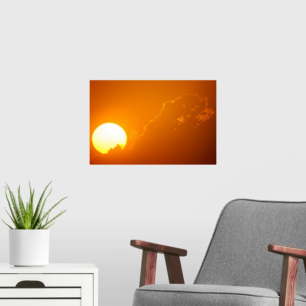 A modern room featuring Telephoto view of the rising sun behind orange clouds, Durban, Kwazulu-Natal, South Africa