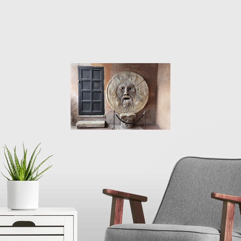 A modern room featuring Horizontal photograph on a large canvas of the a metal door next to the roped off sculpture "The ...