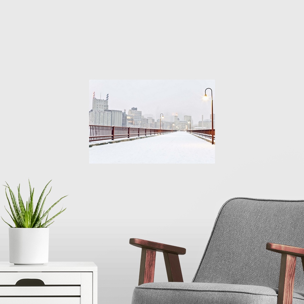 A modern room featuring The Stone Arch Bridge in Minneapolis Minnesota during winter with snow on it.