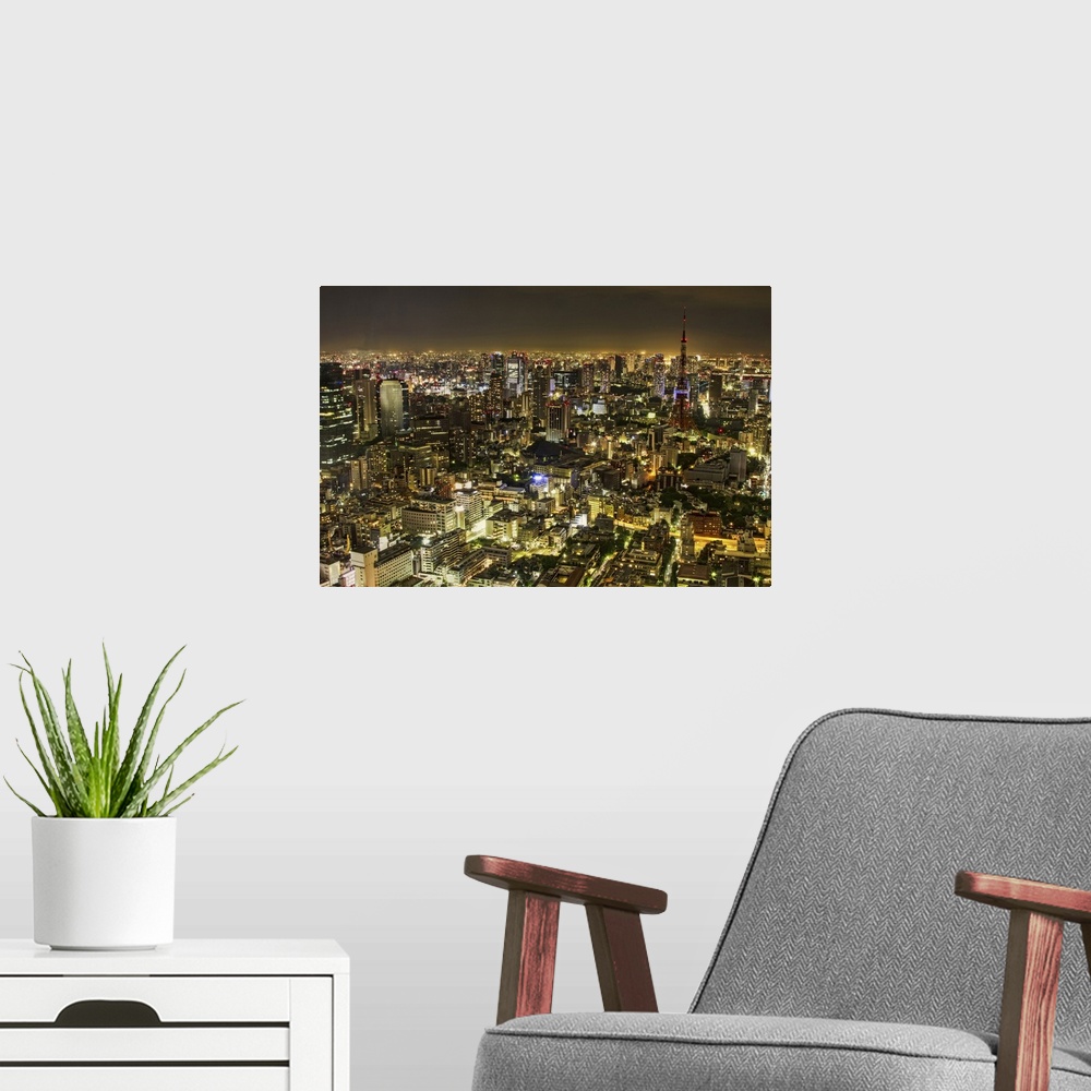 A modern room featuring Horizontal, big aerial photograph of the city of Tokyo, brightly lit at night.