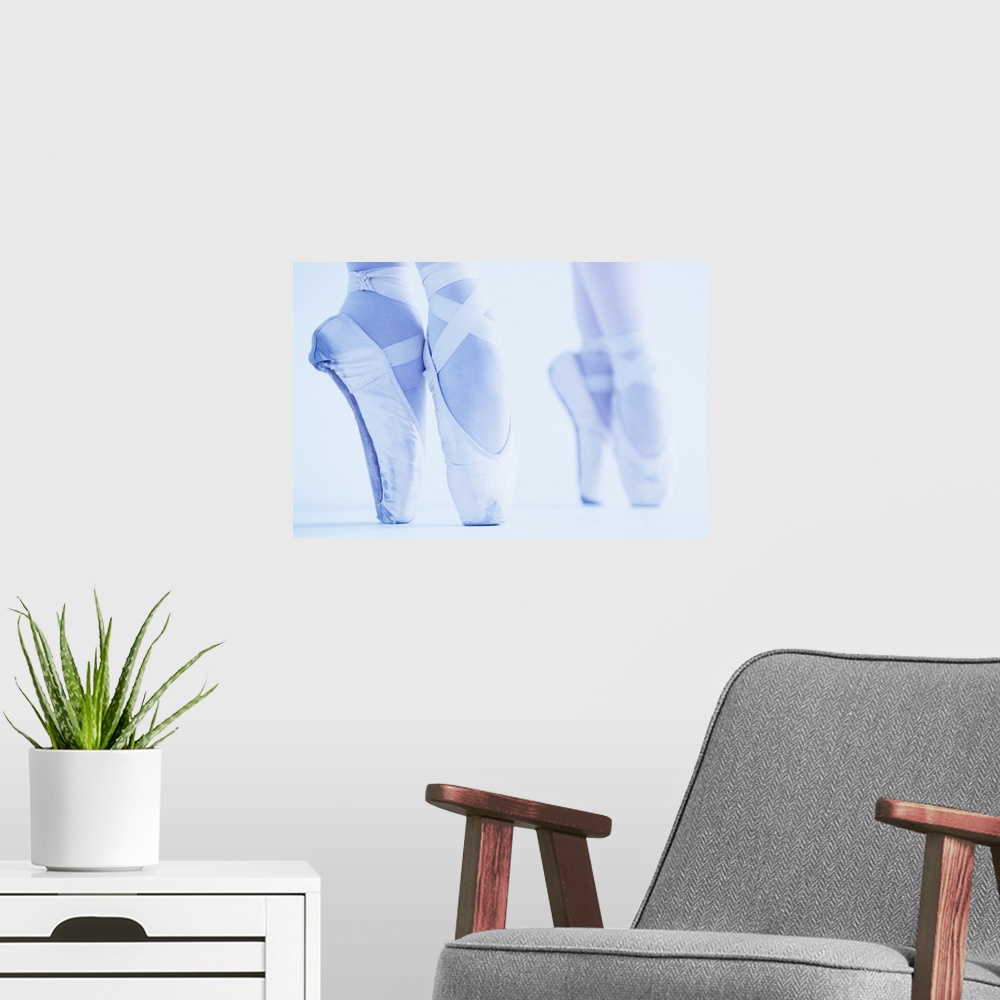 A modern room featuring This low contrast wall art shows two pairs of feet dancing in against a light colored back drop.