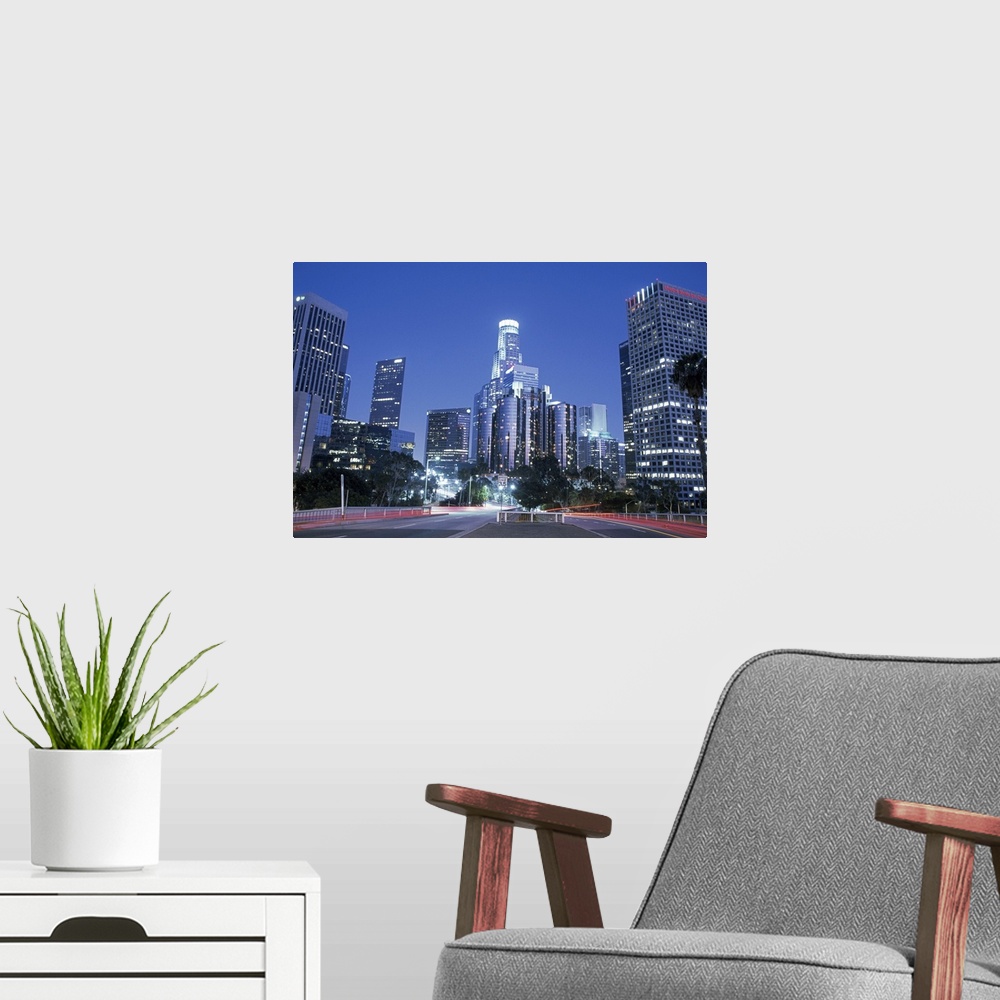 A modern room featuring Perfect for the office, a big photograph of downtown Los Angeles lit up at night with car lights ...