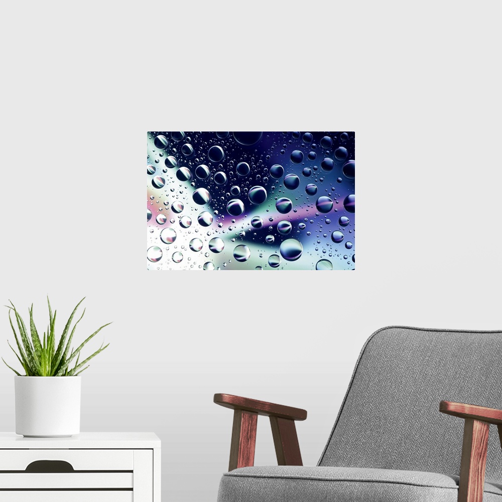 A modern room featuring Horizontal close up photograph on a giant wall hanging of many water droplets sitting on a clear ...