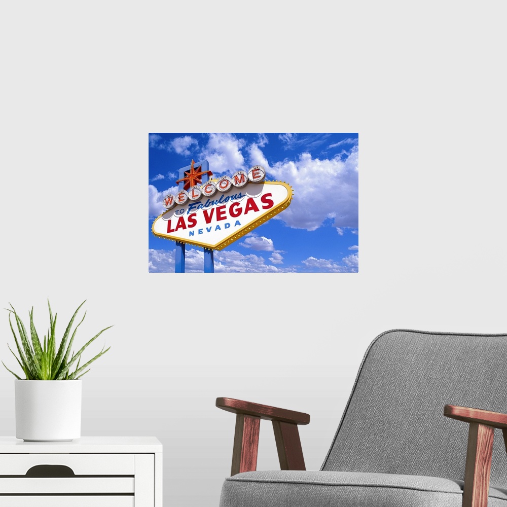 A modern room featuring Giant, landscape photograph of the welcome sign in Las Vegas, Nevada, during the day, against a b...