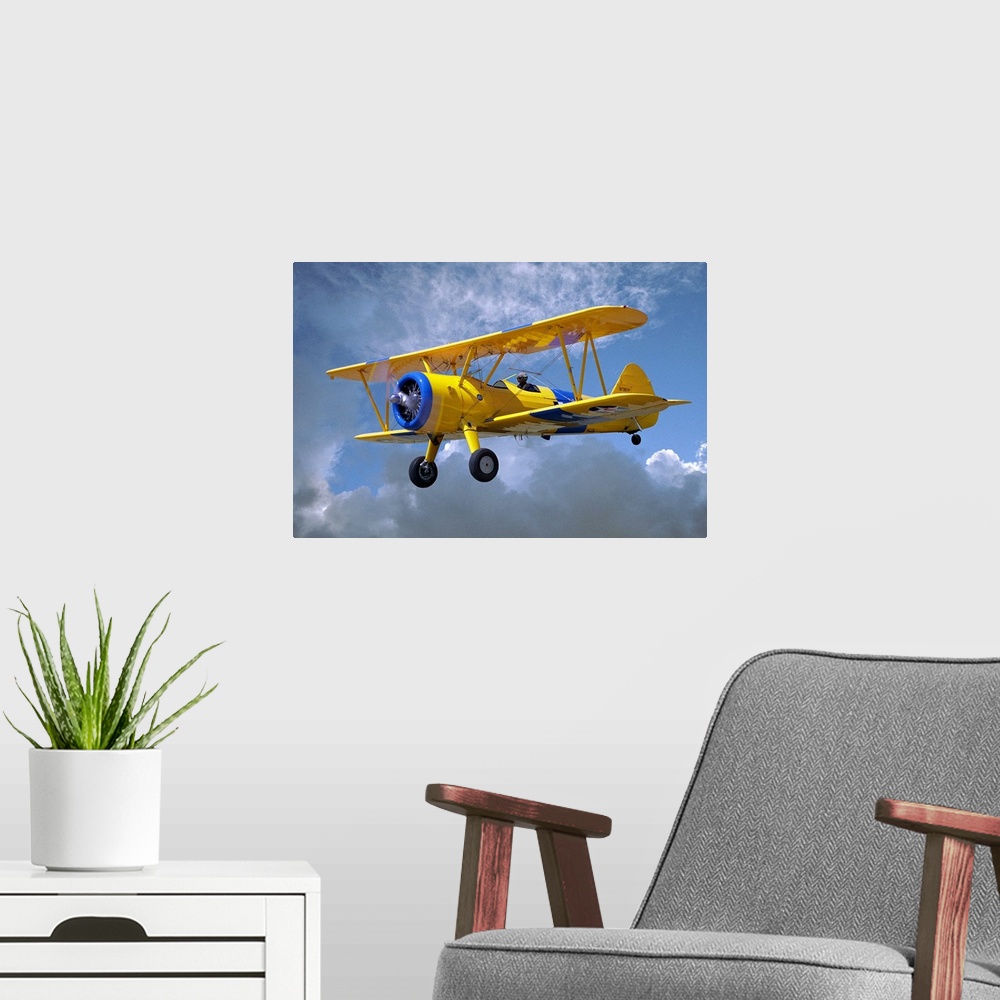 A modern room featuring Yellow Stearman 5YP bi-plane flying in cloudy sky