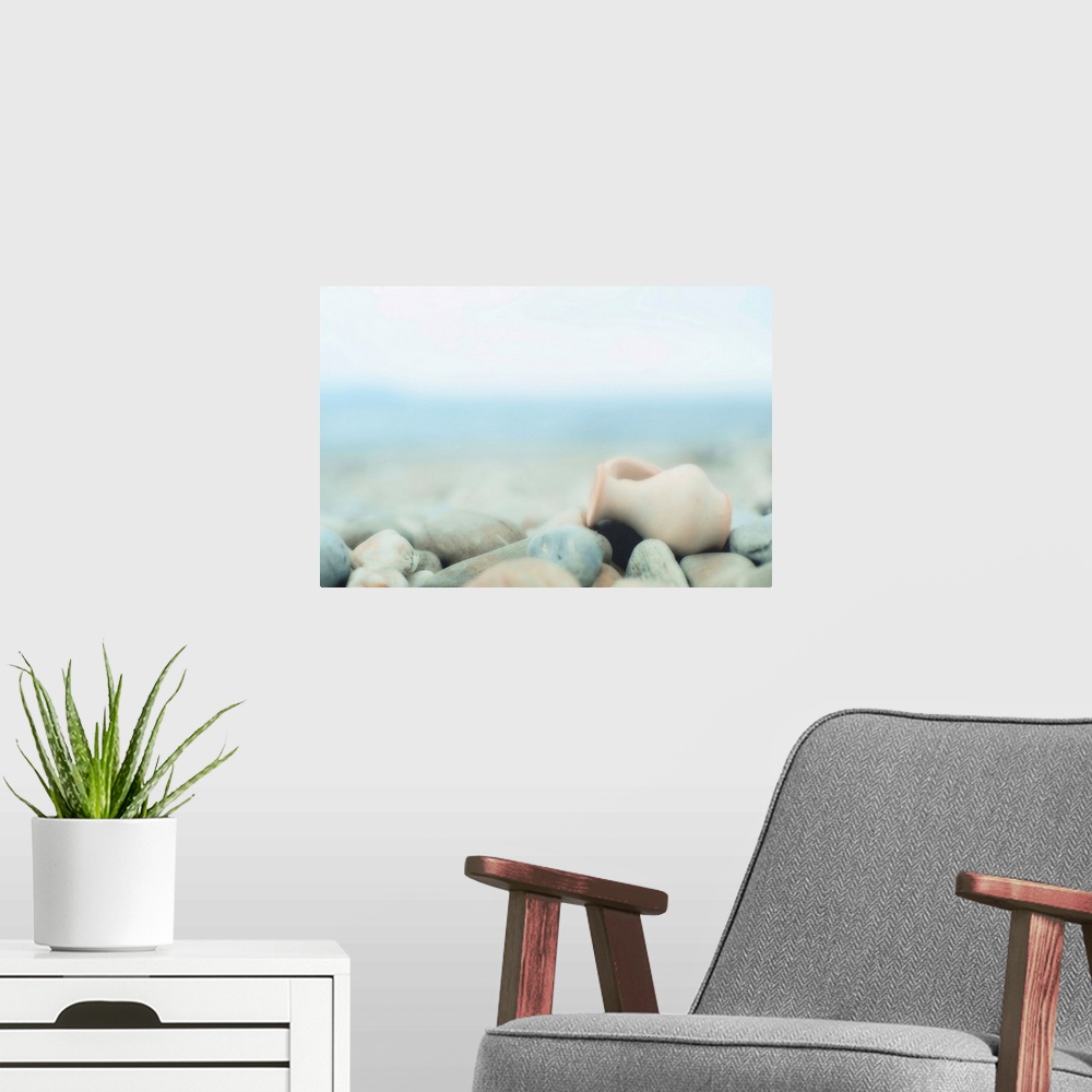 A modern room featuring Zen composition on pebble beach, small amphora on  lies pebbles.