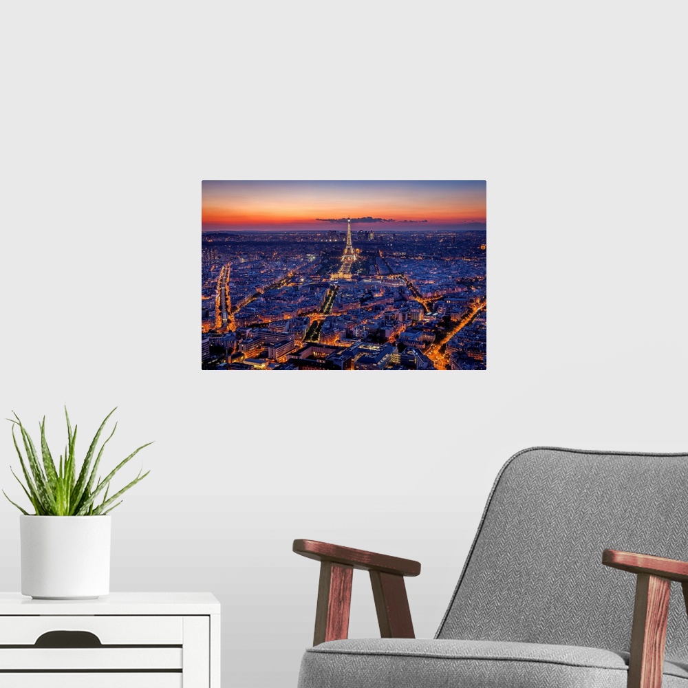 A modern room featuring An aerial photograph of Paris at night with the Eiffel tower seen standing tall.