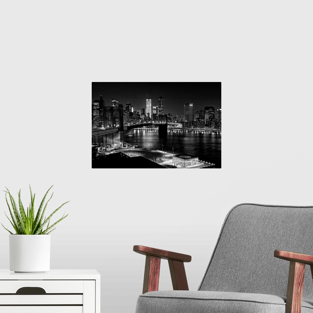 A modern room featuring Black and white photograph of a city skyline at night. With abridge spanning over bay.