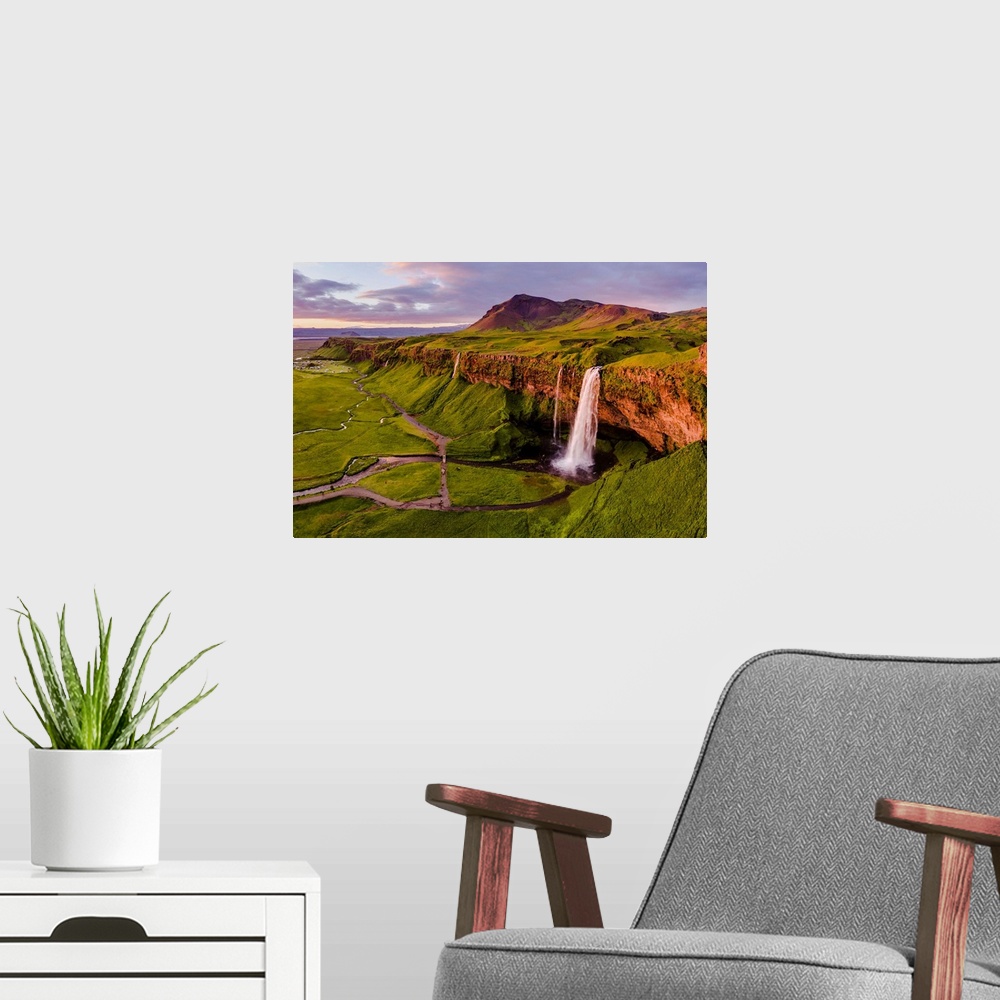 A modern room featuring Aerial drone view of Seljalandsfoss waterfall at sunset, Iceland