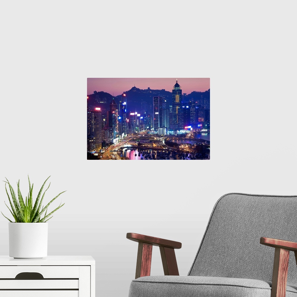A modern room featuring China, Hong Kong, Hong Kong Island, view across harbour to Victoria Peak at sunset.
