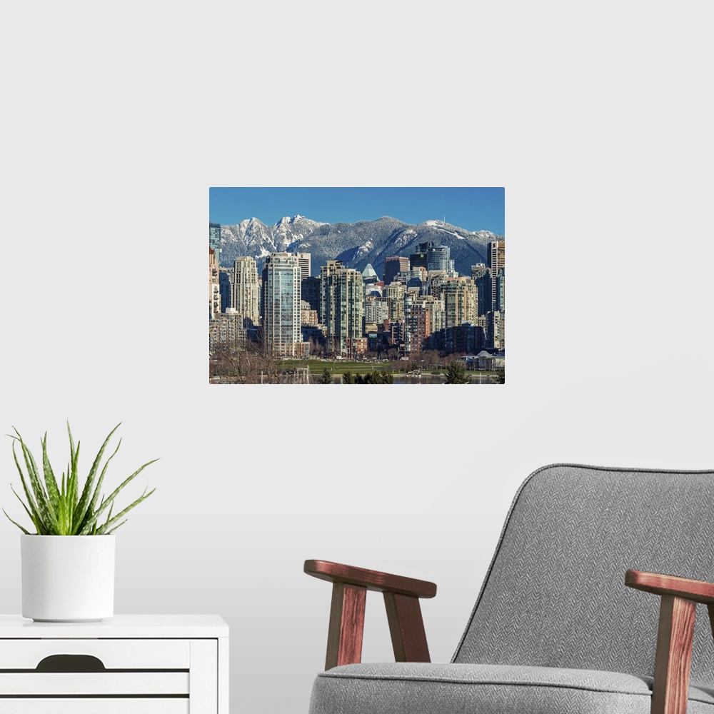 A modern room featuring Downtown skyline with snowy mountains behind, Vancouver, British Columbia, Canada.