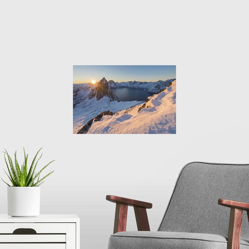 A modern room featuring First lights of sunrise on Mount Segla and Mefjorden framed by the frozen sea seen from peak Hest...