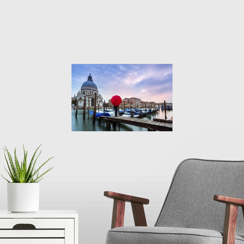 A modern room featuring Italy, Veneto, Venice. Santa Maria della Salute church on the Grand Canal, at sunset, woman stand...