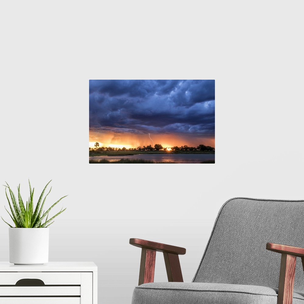 A modern room featuring Lightning shoots from a summer thunderstorm as the sun sets behind it, Okavango Delta, Botswana