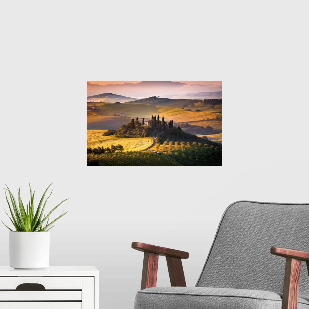 A modern room featuring Podere Belvedere, San Quirico d'Orcia, Tuscany, Italy. Sunrise over the farmhouse and the hills.