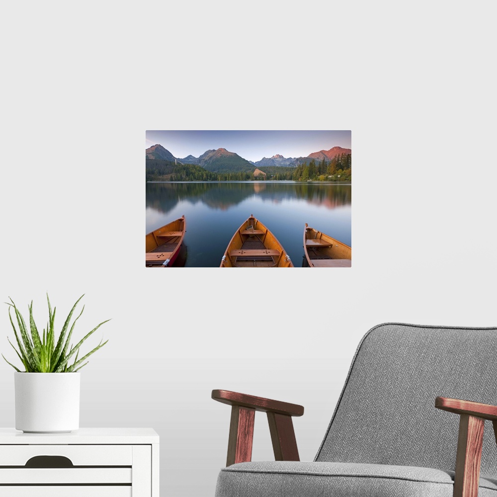 A modern room featuring Rowing boats and mountains beneath a twilight sky, Strbske Pleso Lake in the High Tatras, Slovaki...