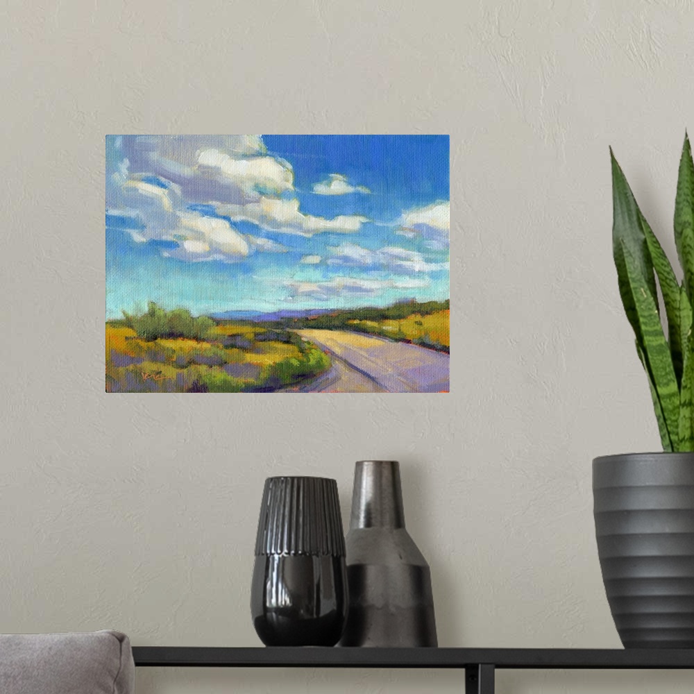 A modern room featuring Contemporary landscape painting of a road going through green fields with clouds and a blue sky a...