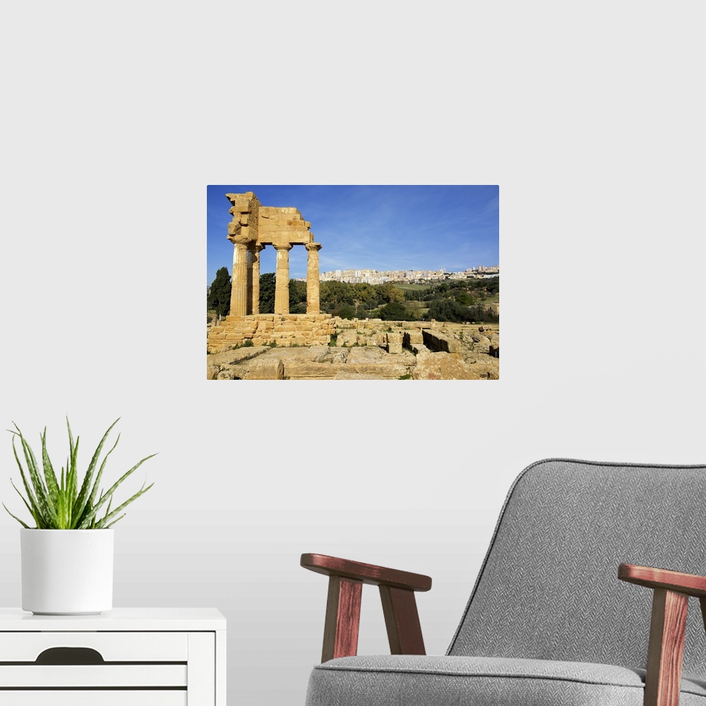 A modern room featuring Agrigento Greek ruins, modern city in the background, Sicily, Italy.