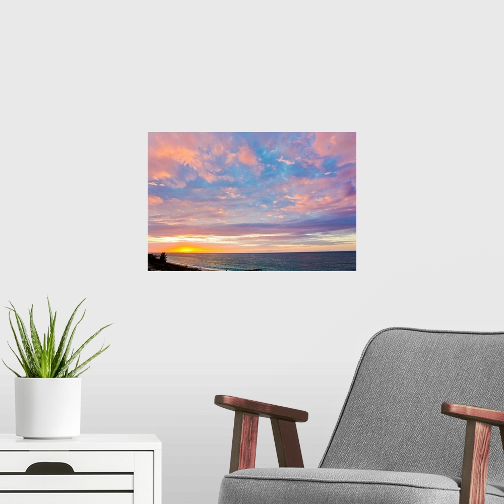 A modern room featuring A beautiful delicate pink and purple sky at sunset over Grace Bay, and the shore.