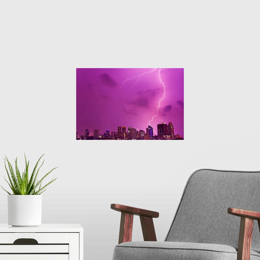 A modern room featuring A intense thunderstorm with lightning over the skyline of Manila.