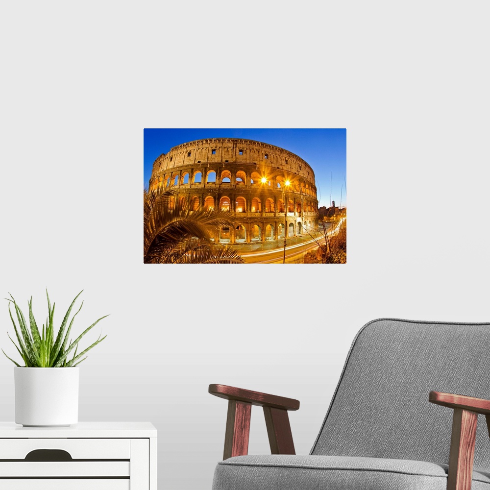 A modern room featuring The ancient Roman Colosseum casts an illuminated golden light at dusk.