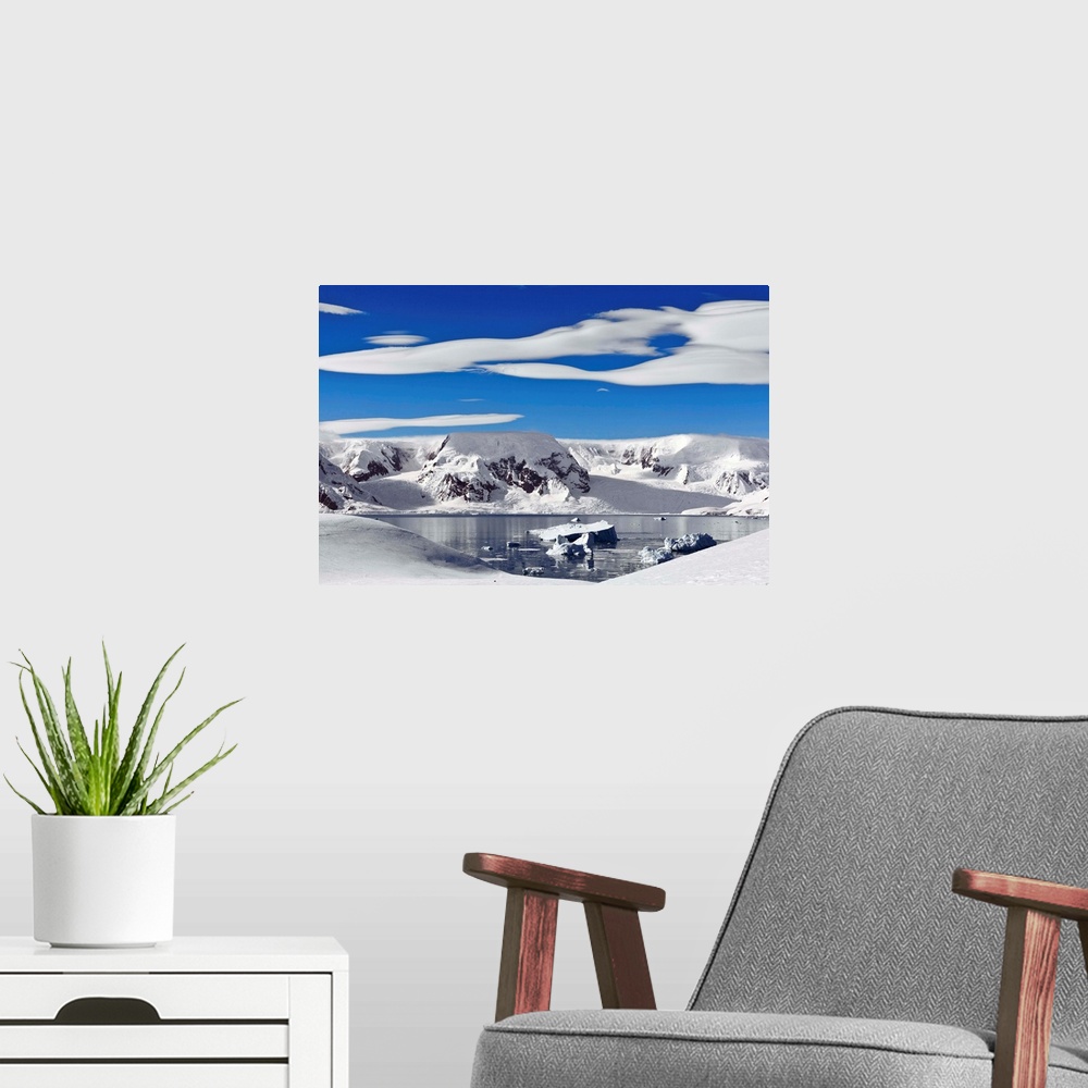 A modern room featuring Snow-covered mountains along coast, Antarctica.