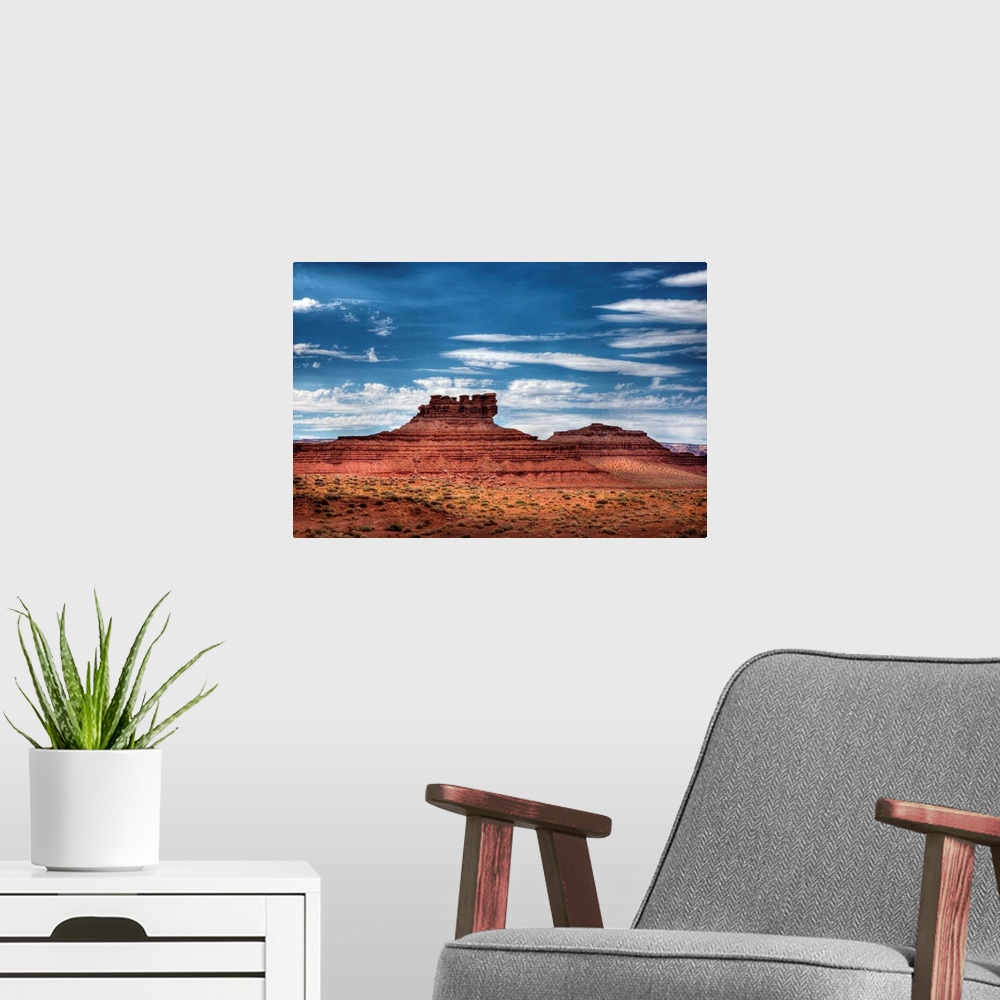 A modern room featuring A photograph of red desert landscape with an intricate rock formation in the distance.