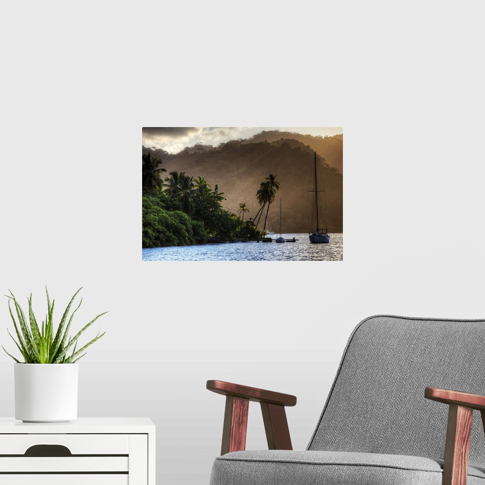 A modern room featuring A photograph of a tropical destination with a silhouetted sailboat in the distance.