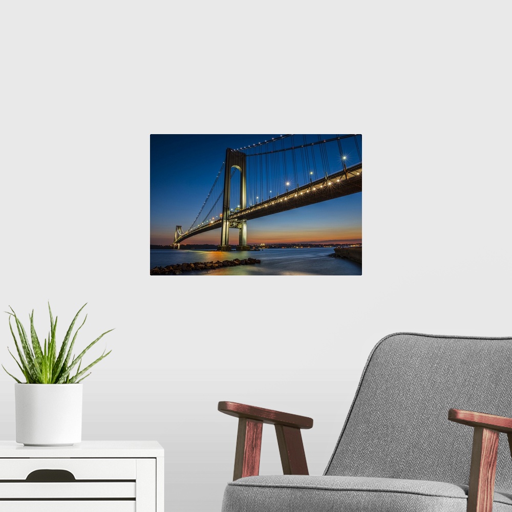 A modern room featuring A photograph of the Verrazano-Narrows Bridge at twilight.