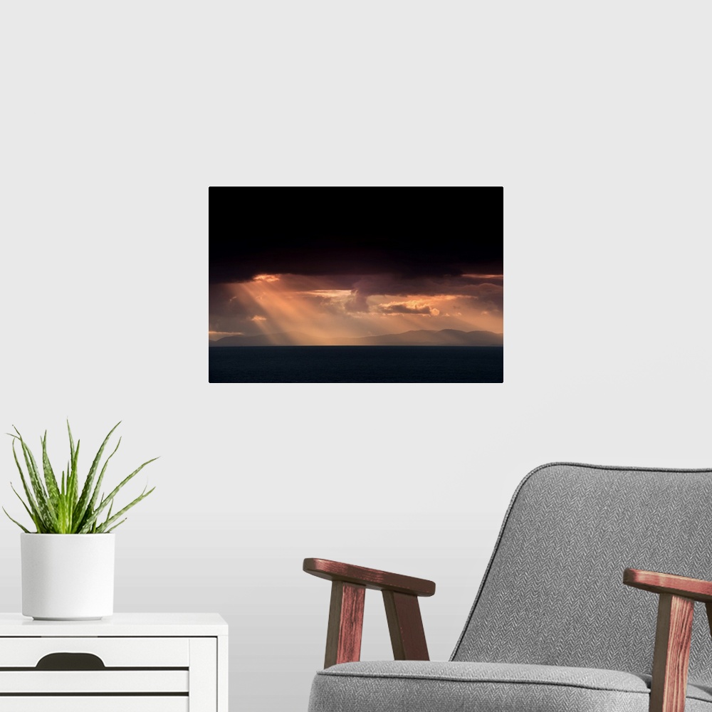 A modern room featuring Fine art photo of beams of light coming from dark clouds over a lake.