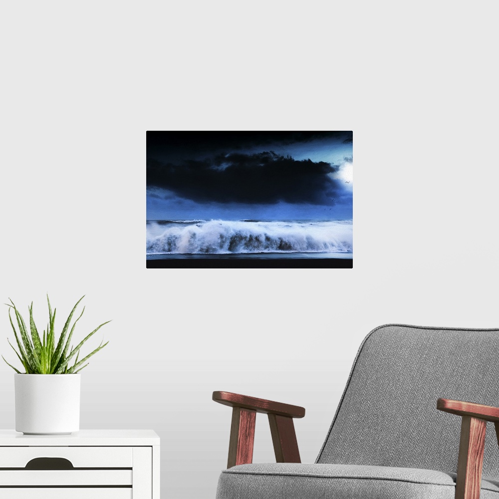 A modern room featuring A photograph of a seascape under a dark cloudy sky.
