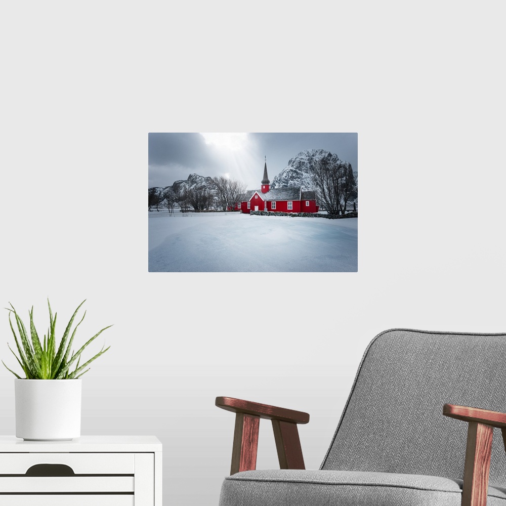 A modern room featuring A photograph of red church seen in a wintry landscape.