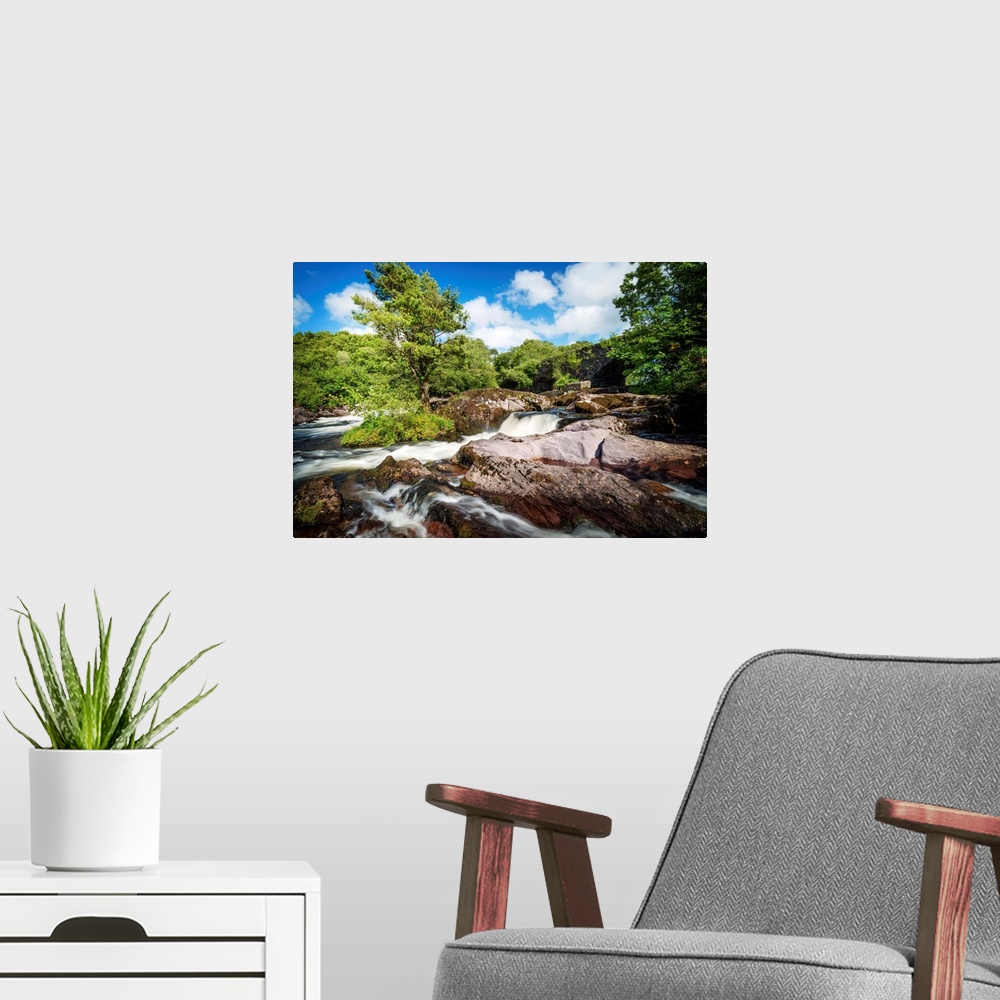 A modern room featuring Rushing river flowing over and around massive rocks.