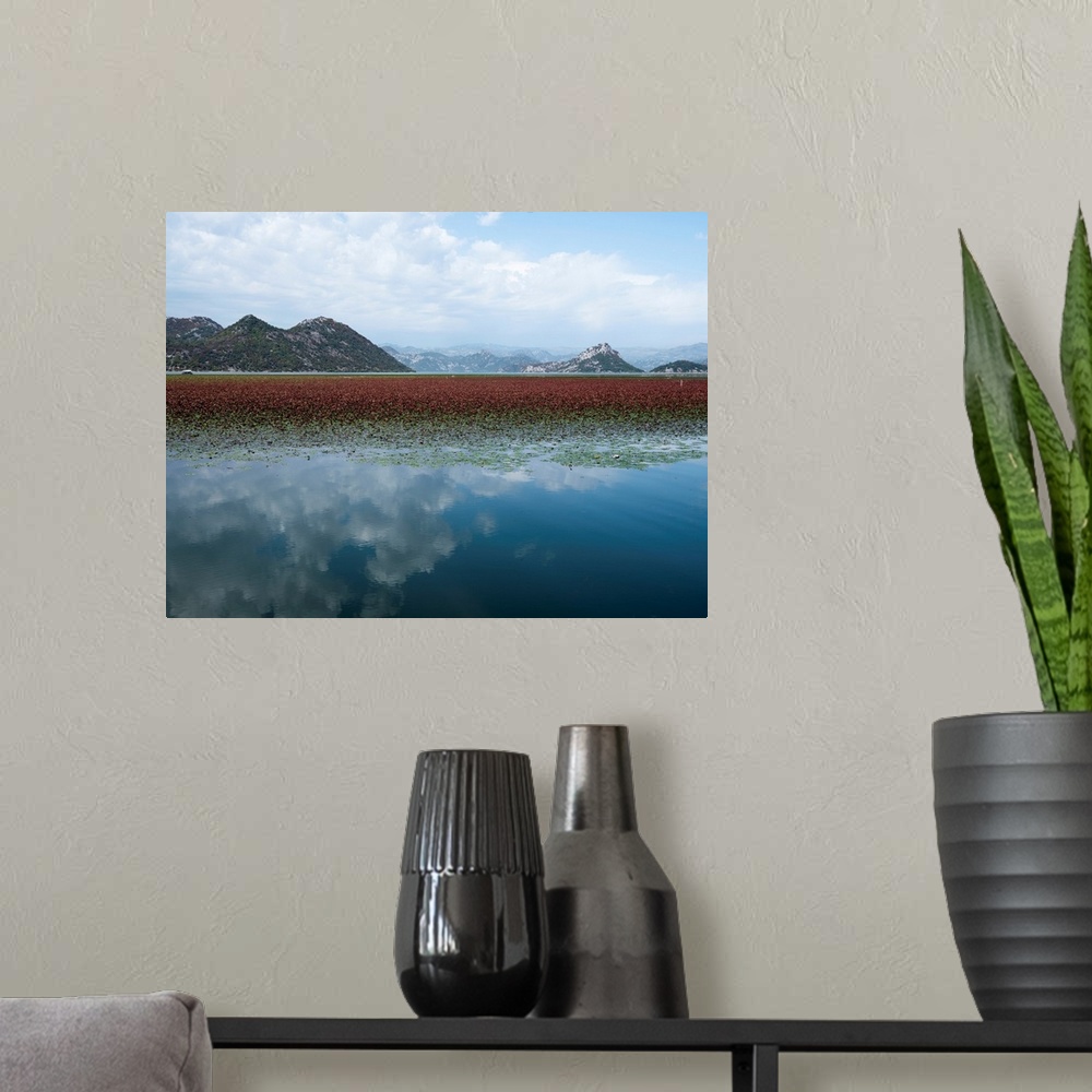 A modern room featuring Photograph of a beautiful landscape with mountains and a lake that is reflecting the white clouds...