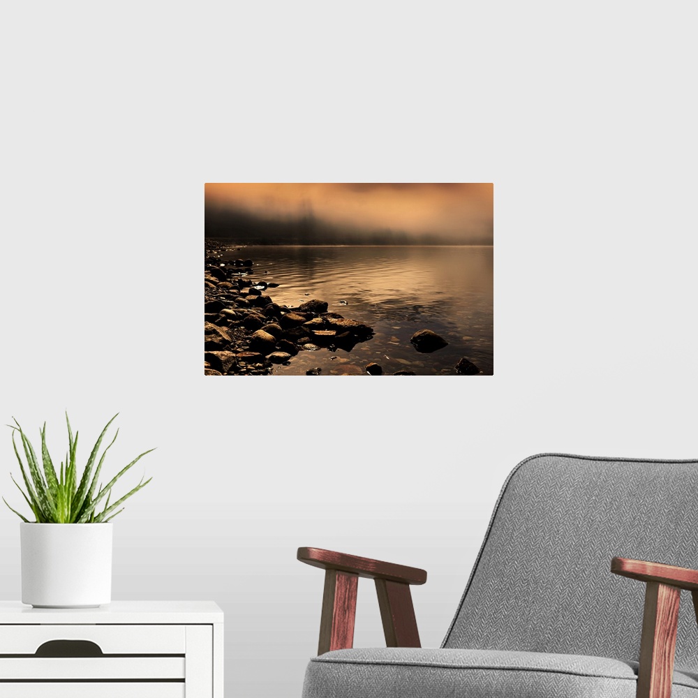 A modern room featuring Landscape photograph of a rocky shore with orange fog covering the background.
