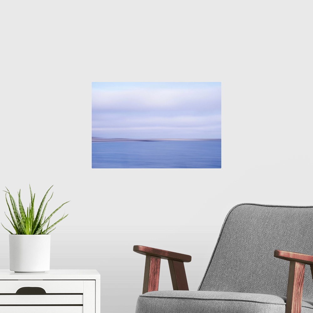 A modern room featuring Artistically blurred photo. View on the beach and dunes of the North Sea; land and sea in an inev...