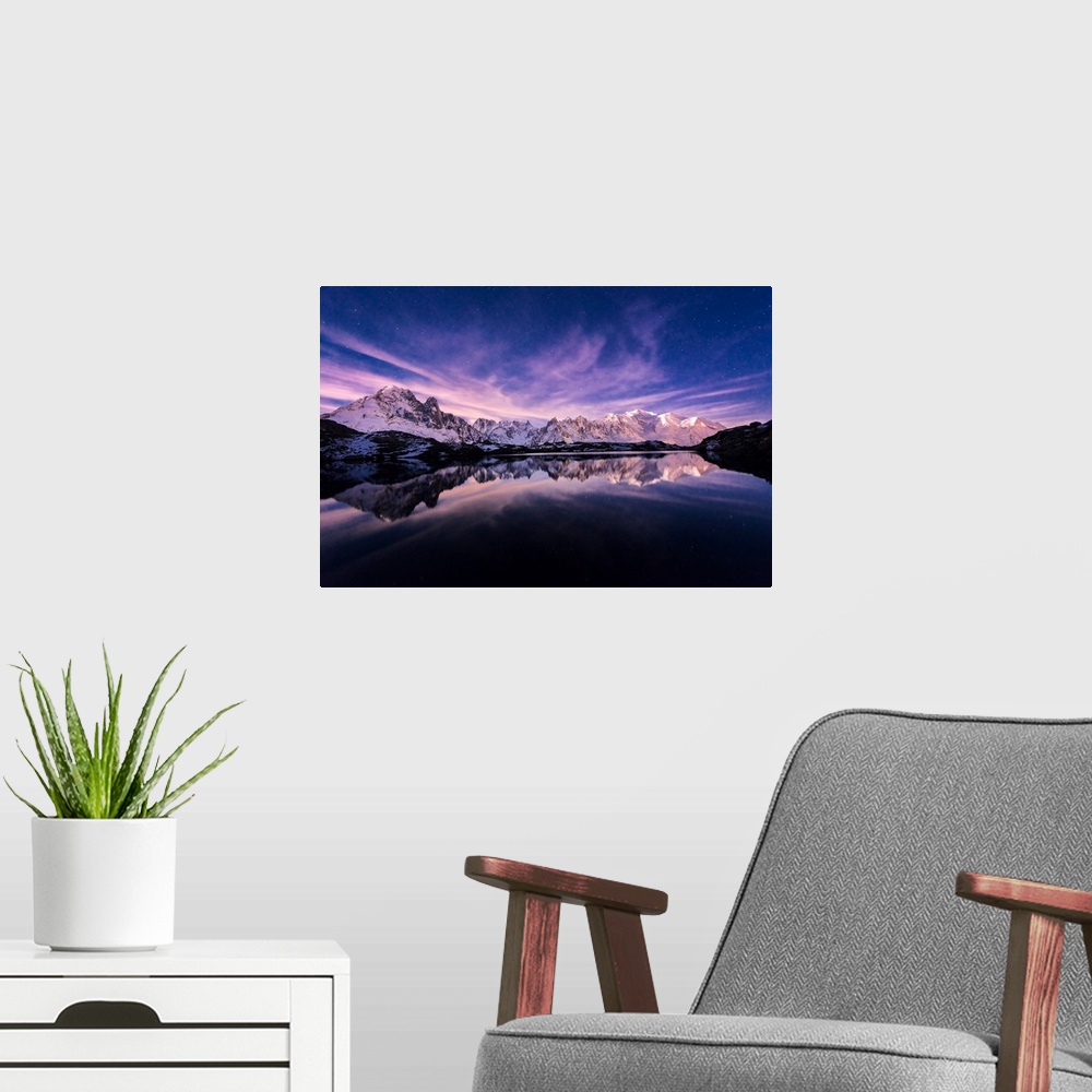 A modern room featuring Fine art photograph of a snowy mountain range reflected in the water under a lavender sky in France.