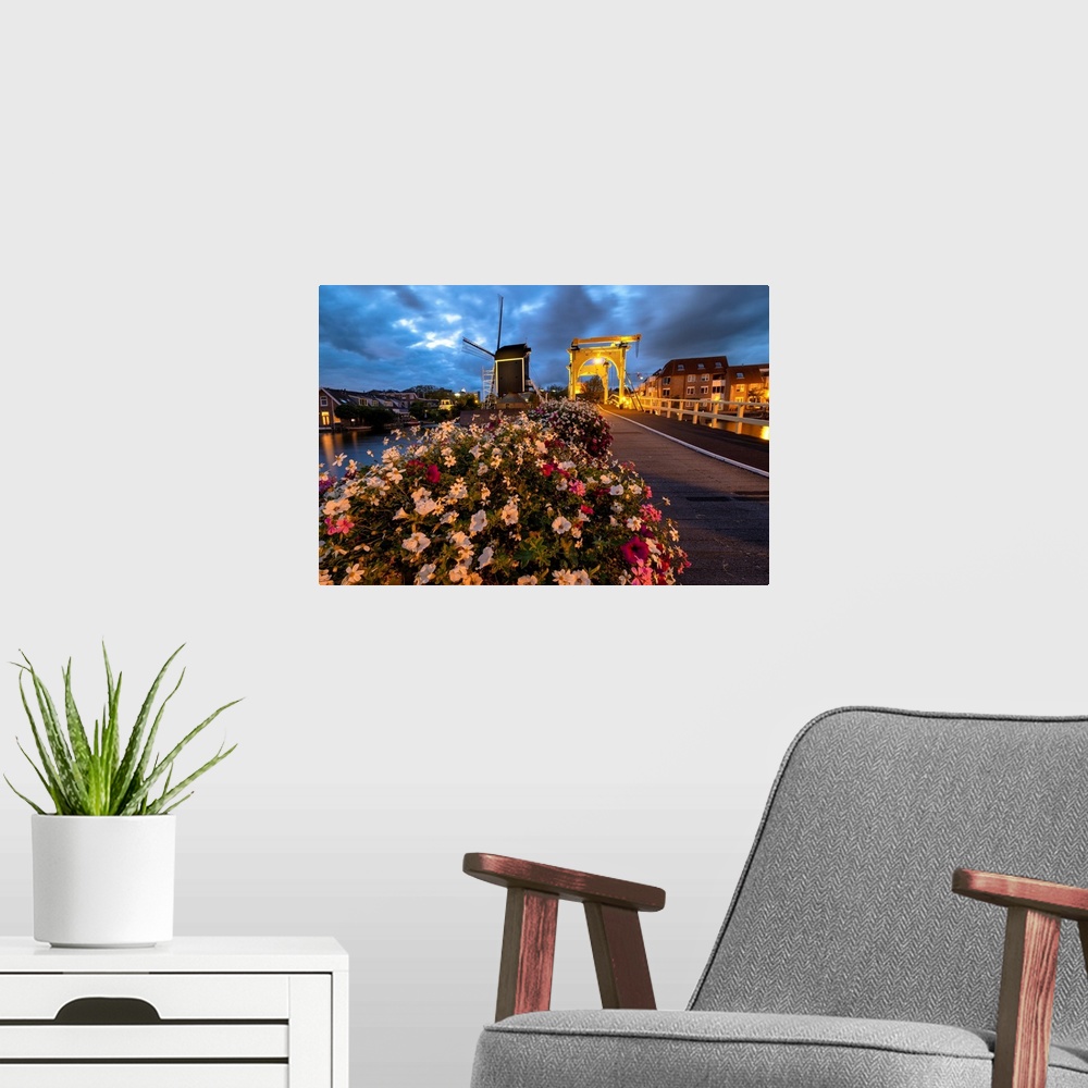 A modern room featuring Drawbridge and windmill at night with blooming flowers, Leiden, South Holland, Netherlands.