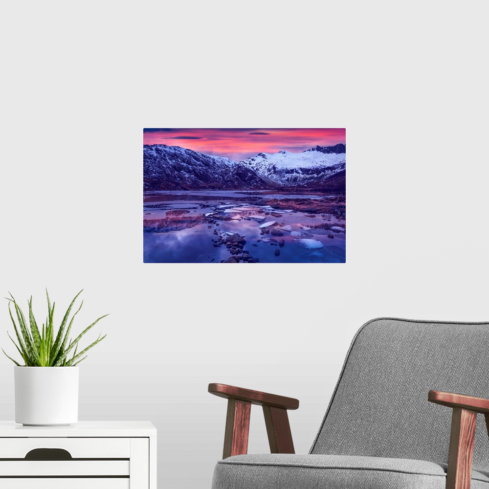 A modern room featuring Snowy mountains in Lofoten, Norway, by a glacial lake at sunset.