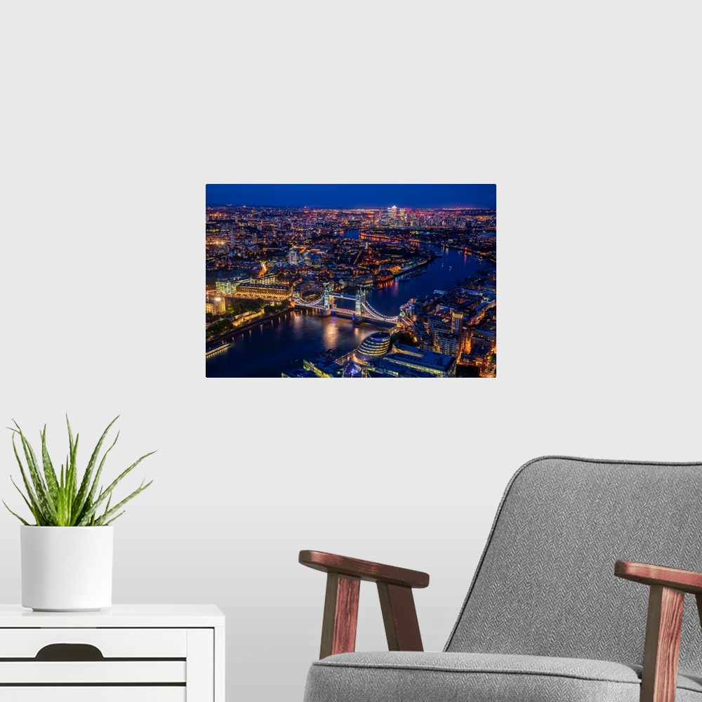 A modern room featuring Aerial photograph of Tower Bridge, River Thames, and the city of London lit up at night. View fro...