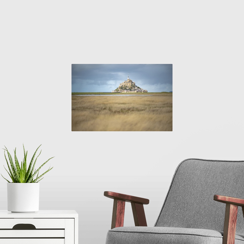 A modern room featuring Mont Saint Michel in France in the middle of the meandres under a blue sky.