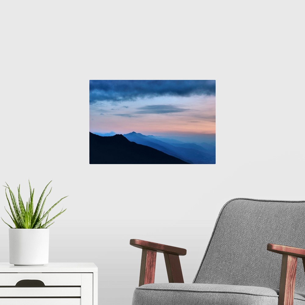 A modern room featuring Mountains landscape with infinite horizon at early moning in France with sweet pink clouds above.