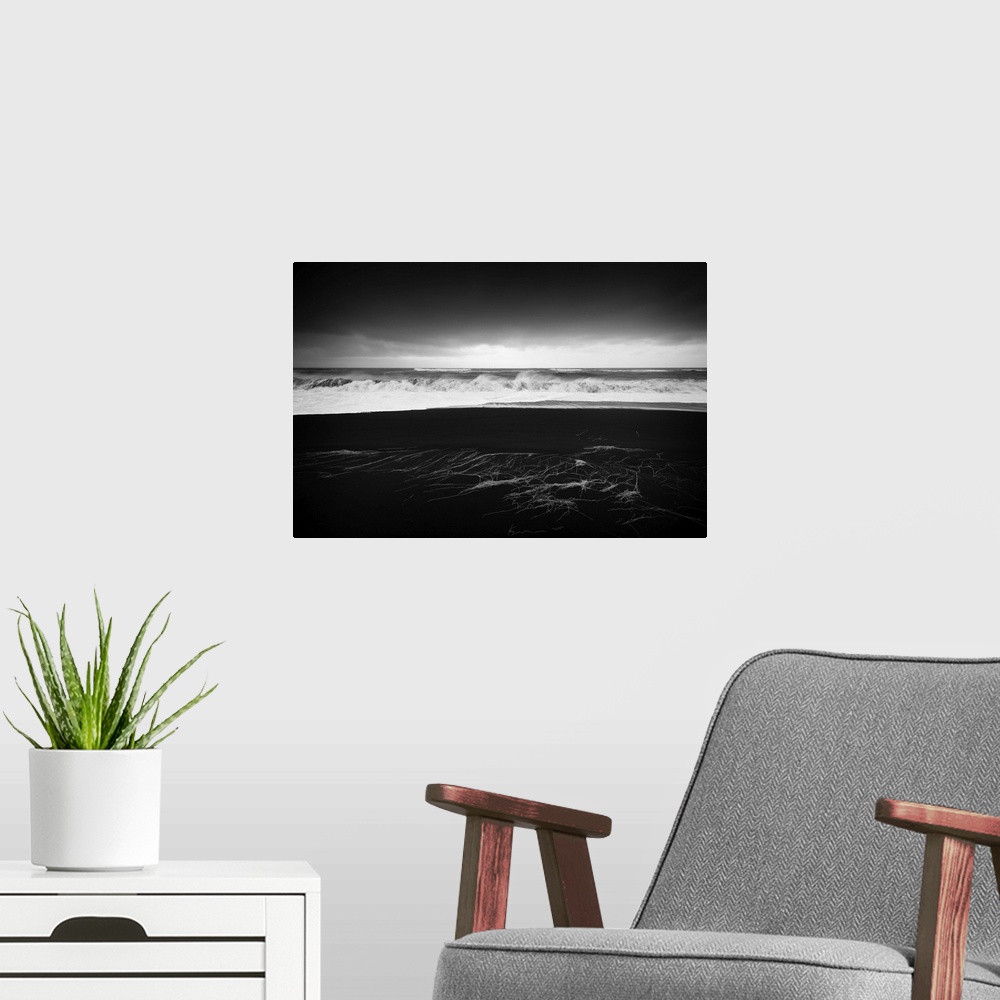 A modern room featuring A photograph of a dark coastline under a dark sky.