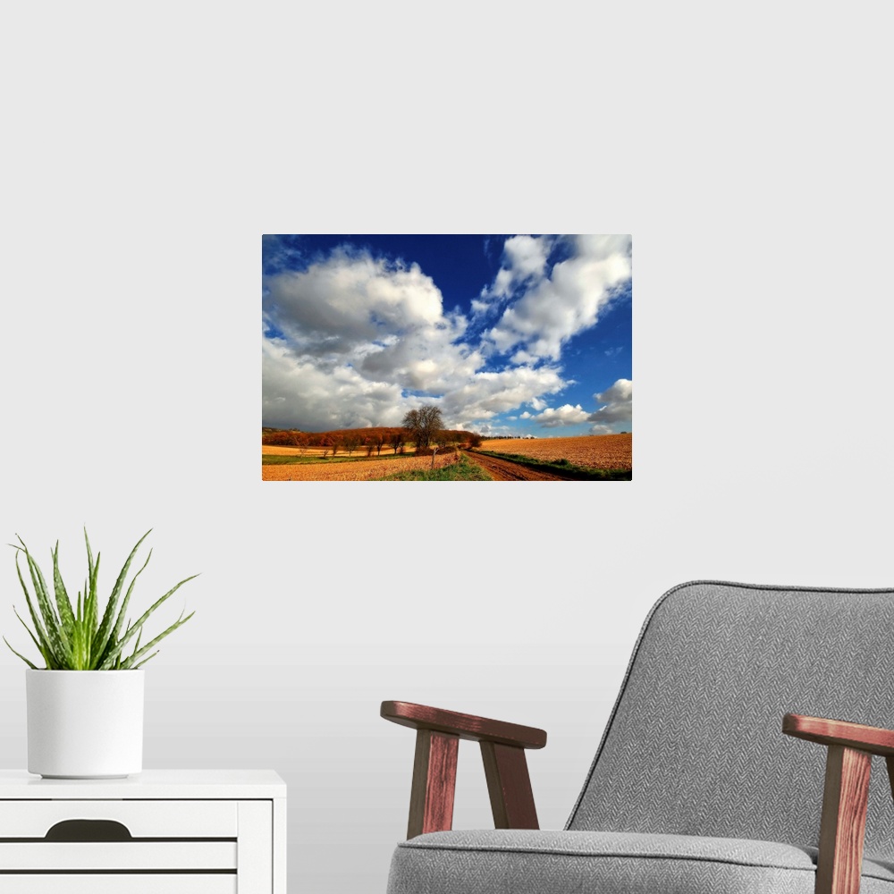 A modern room featuring Blue sky with heavy clouds above the countryside